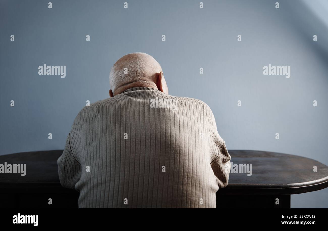 Rückansicht auf den Senior-Mann, der am Tisch sitzt Stockfoto Rückansicht auf den Senior-Mann, der am Tisch sitzt Stockfoto