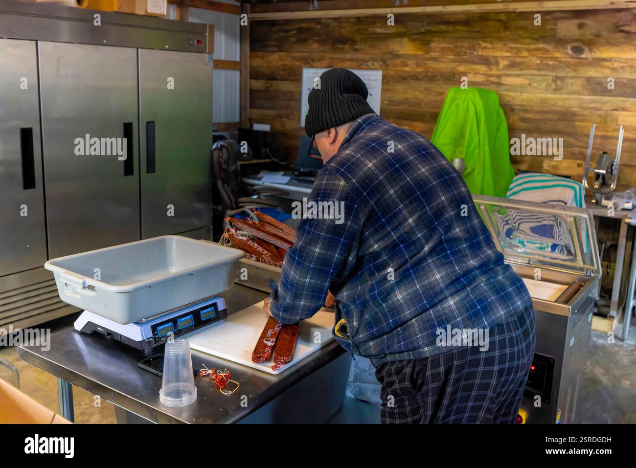 Siler City, NC, USA – 15. Februar 2025: Ein Wurstmeister macht Salami und bereitet sie für den Versand vor. Stockfoto