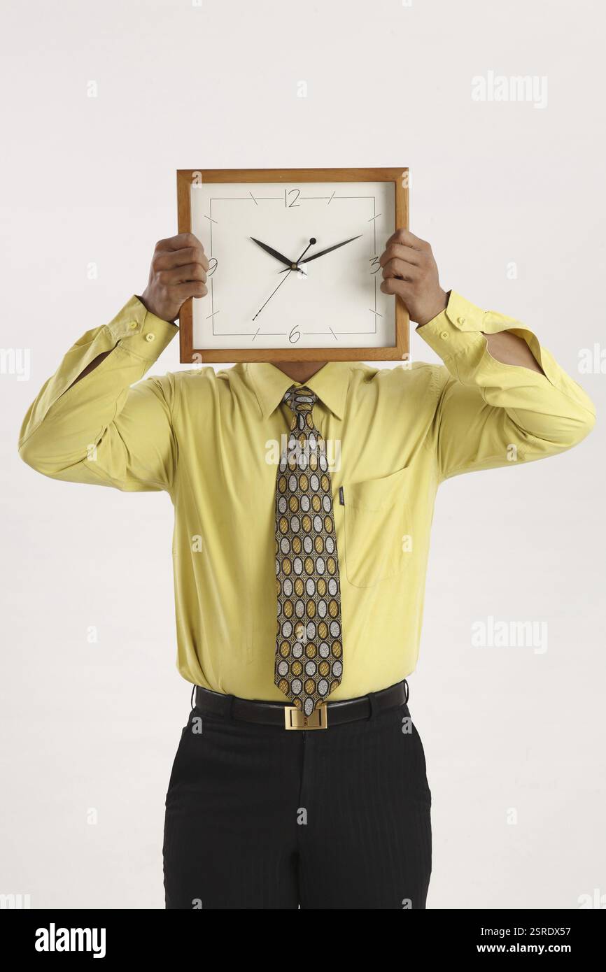 Geschäftsmann Wanduhr in beide Hände vors Gesicht halten und versteckt es Herr #703T Stockfoto