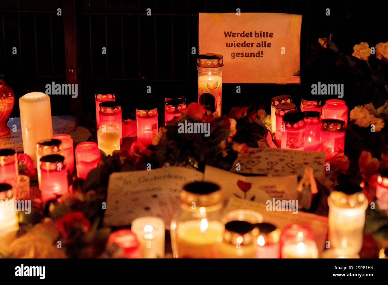 München, Deutschland. Februar 2025. Schild mit der Aufschrift werde bitte wieder alle gesund! - Bitte geht es allen wieder gut! Anlässlich der Gedenkfeier mit Blumen und Kerzen am Ort eines mutmaßlichen Terroranschlags in der bayerischen Hauptstadt München am 13. Februar. Ein 24-jähriger Afghane hat mehrere Personen verletzt, die an einem VERDI-Protest mit einem Auto teilnahmen, eine 37-jährige Frau und ein 2-jähriges Kind sind zwei Tage später ihren Verletzungen erliegen. Quelle: Andreas Stroh/Alamy Live News Stockfoto