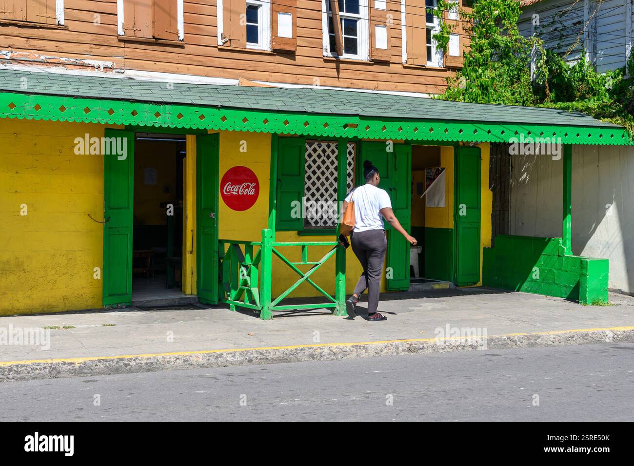 Der Kunde betritt Ein traditionelles kleines Café mit schnörkelloser Basisfront, außer Einem Coca Cola Schild auf der Bay Road Basseterre St. Kitts & Nevis Stockfoto
