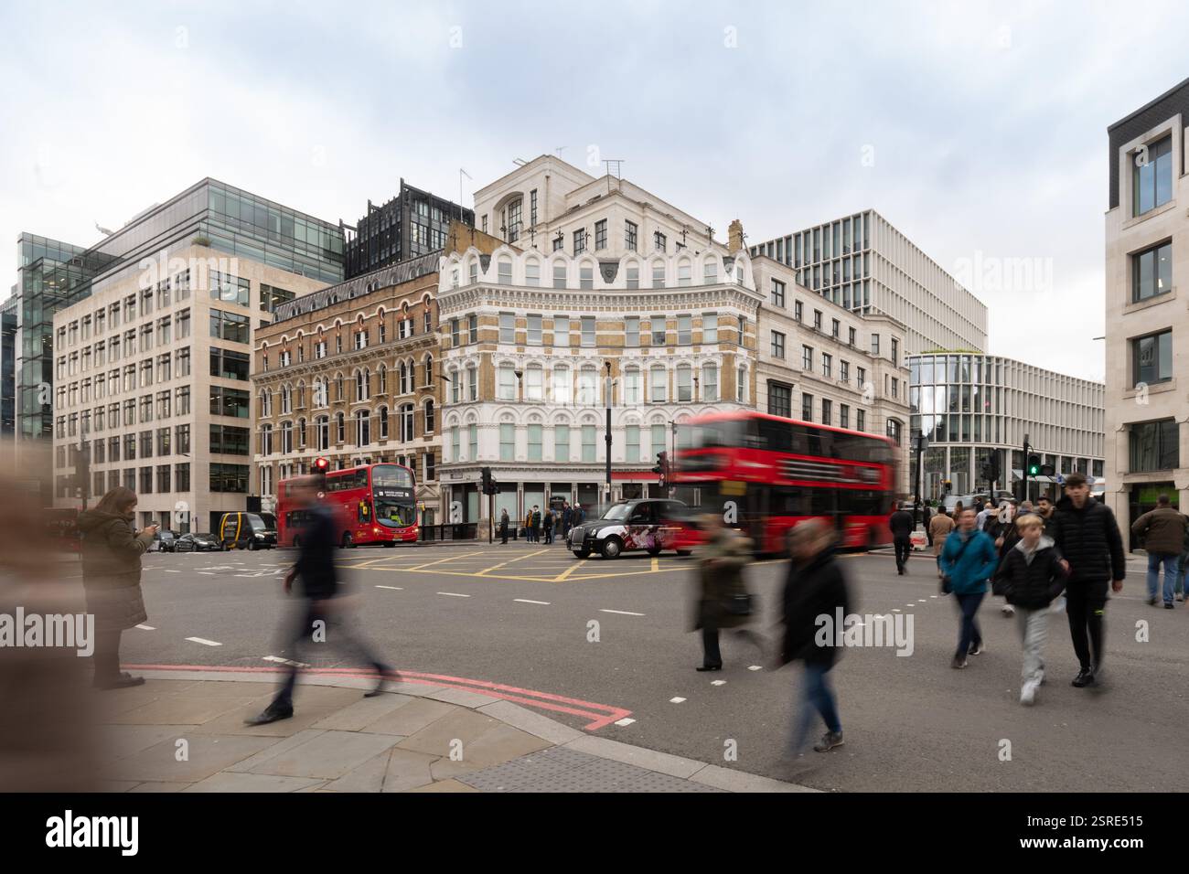 Fußgänger überqueren eine geschäftige Londoner Straße und weichen Bussen und Taxis aus. Ludgate Circus Stockfoto