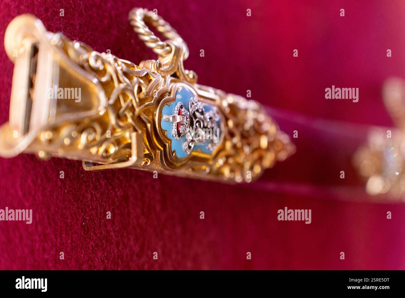 Kunstvoller goldener Schwertgriff, wahrscheinlich zeremoniell, mit königlichem Wappen. Details zeigen Handwerkskunst. Stockfoto