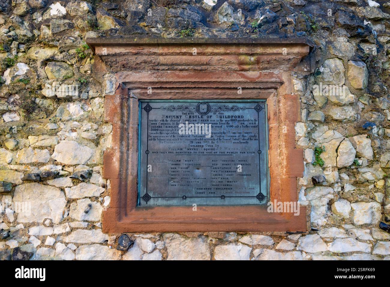 Gedenktafel an einer Mauer in der Nähe des Donjons von Guildford Castle. Mit Details über den Verkauf des Grundstücks an den stadtrat. Februar 2025. Stockfoto