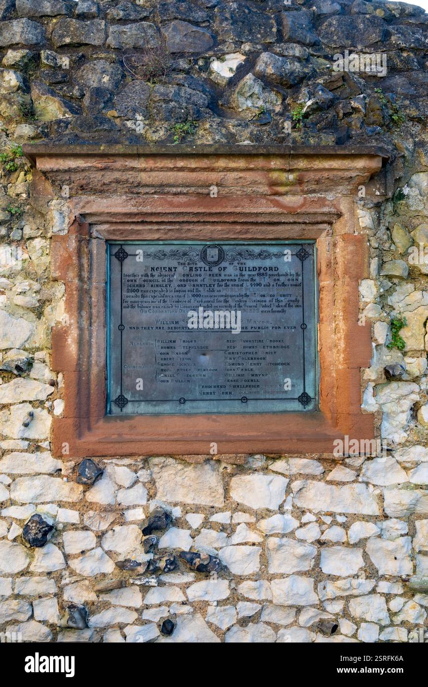 Gedenktafel an einer Mauer in der Nähe des Donjons von Guildford Castle. Mit Details über den Verkauf des Grundstücks an den stadtrat. Februar 2025. Stockfoto