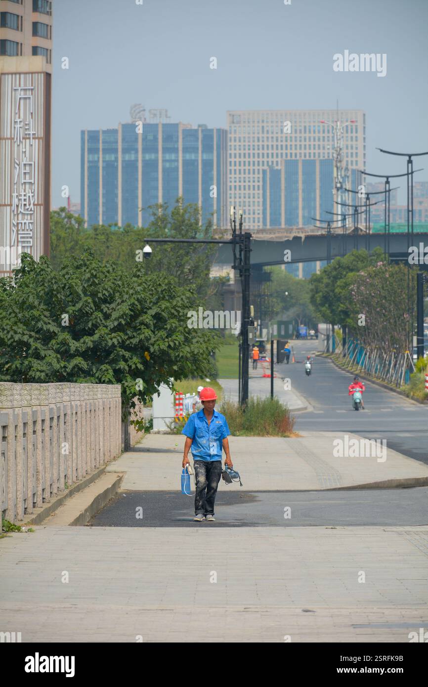 Ein chinesischer Handarbeiter geht zur Arbeit, mit seinen Werkzeugen und einer Flasche Wasser. September 2020. Stockfoto
