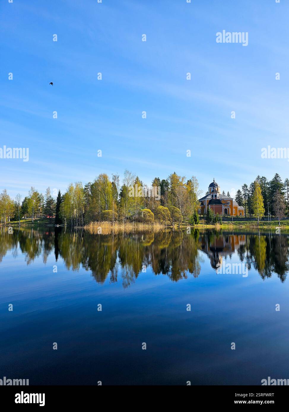 Wunderschöne Landschaft im Sommer mit See, blauem Himmel und Kirche - Smartphone-aufgenommenes Stockfoto