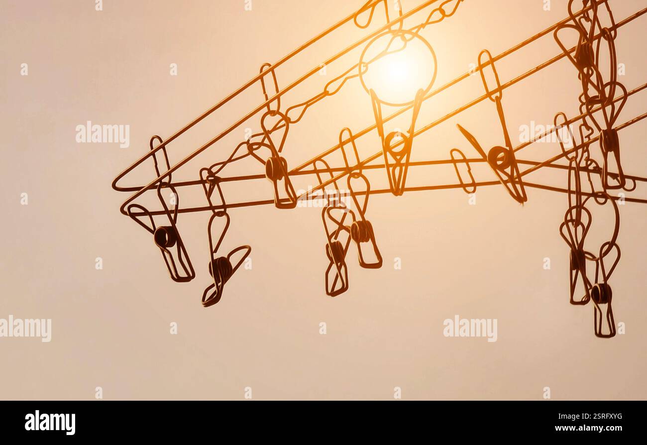 Die Silhouette der farbenfrohen Kleiderschränke hängt an einer Wäscheleine Stockfoto