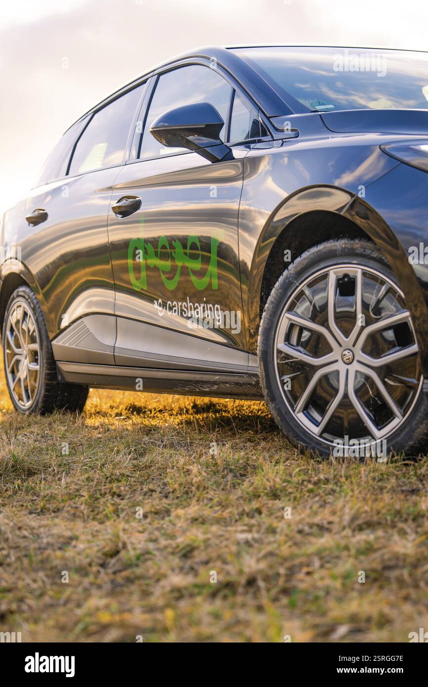 Nahaufnahme eines schwarzen Autos mit hervorgehobenen Reifen und Logo bei Sonnenuntergang, E-Car Sharing, Deer Mobility, MG4, Calw, Deutschland, Europa Stockfoto