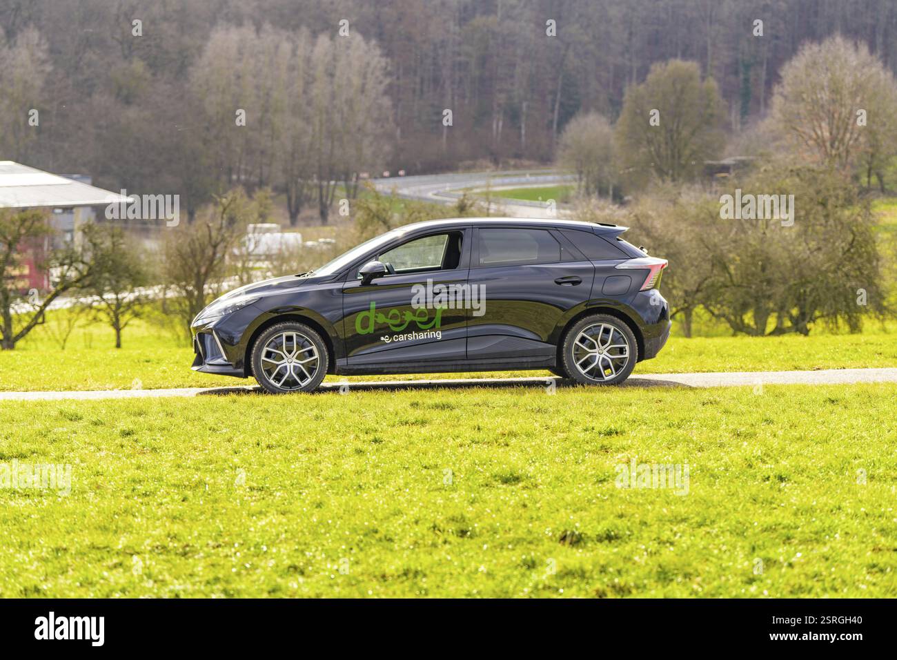 Schwarzes Auto mit Logo auf einer asphaltierten Straße in grüner Umgebung, E-Car Sharing, Deer Mobility, MG4, Calw, Deutschland, Europa Stockfoto