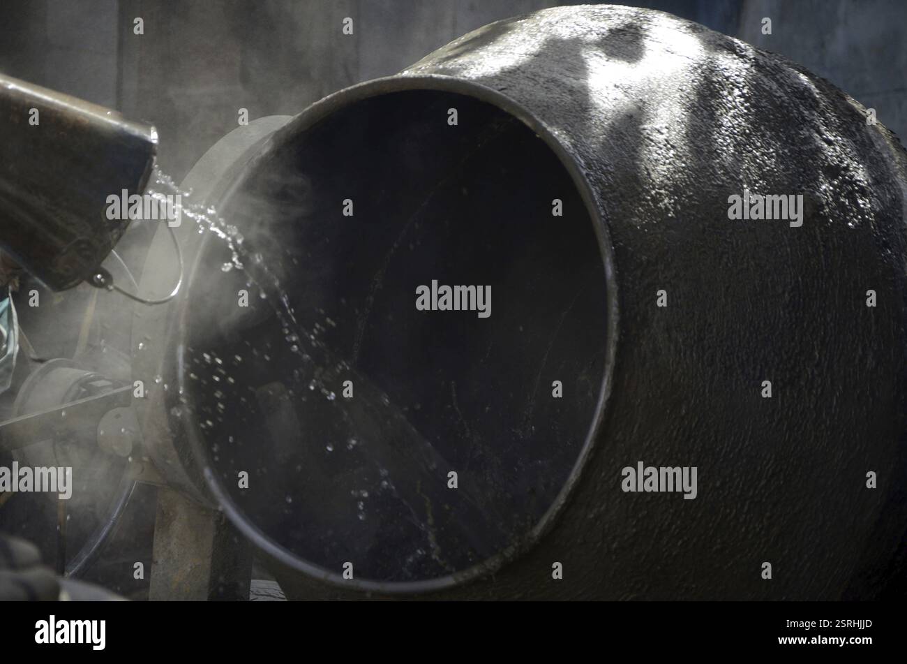 Gießen von Wasser in Zementmischer Indien Asien Stockfoto