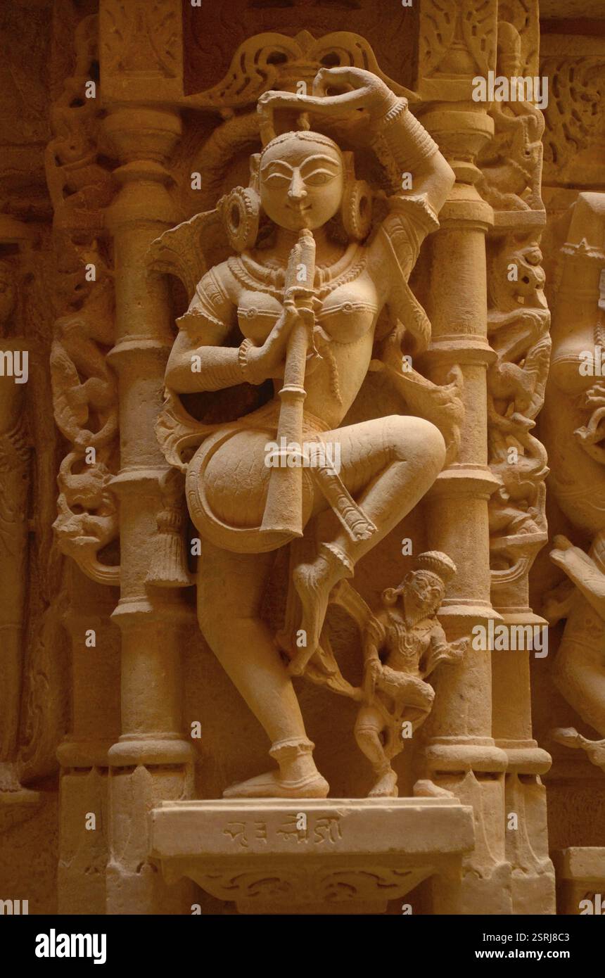 Frau, die Flötenskulptur auf dem Jain-Tempel spielt, jaisalmer, Rajasthan, Indien, Asien Stockfoto