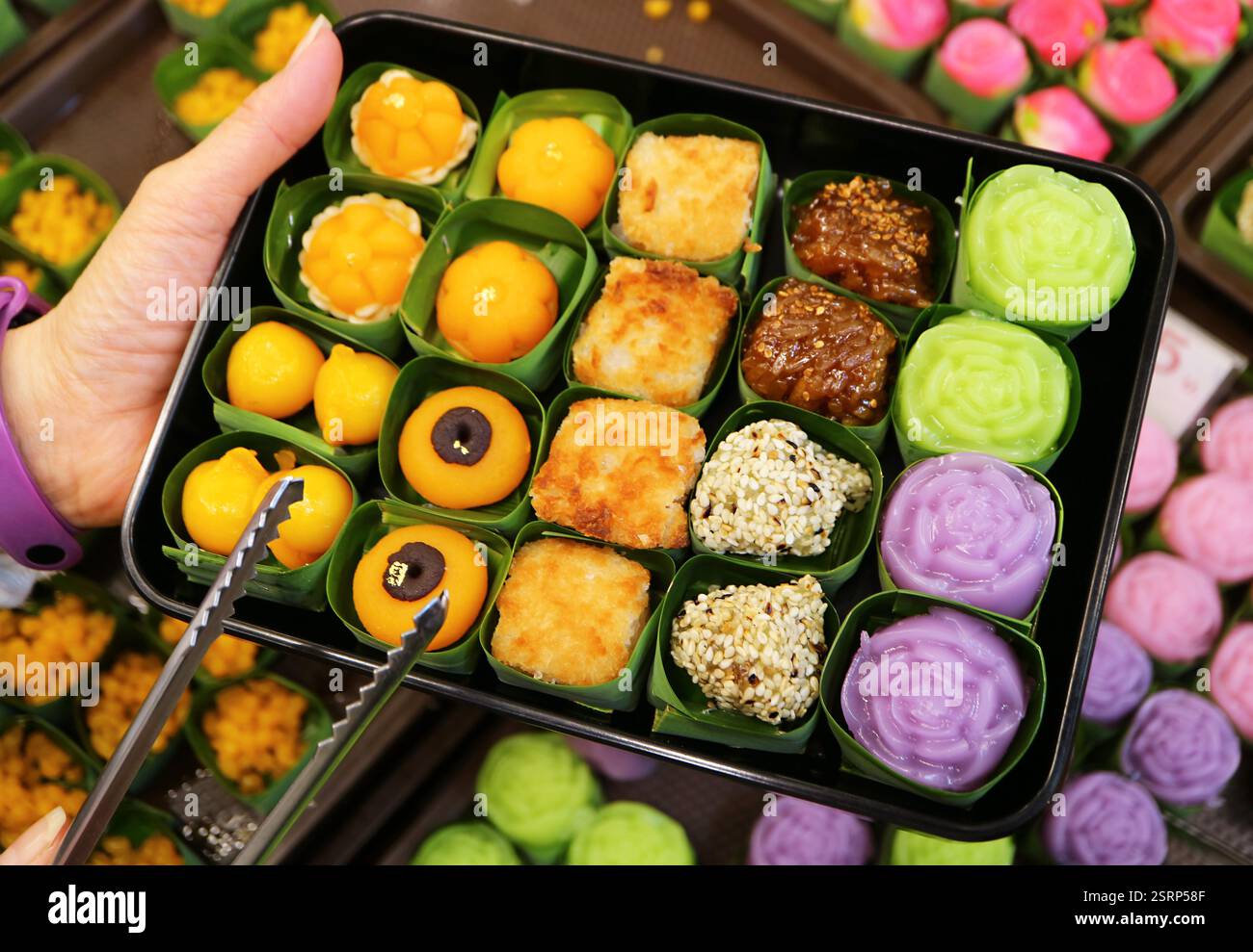 Gäste wählen köstliche traditionelle thailändische Desserts in einem Süßwarenladen Stockfoto