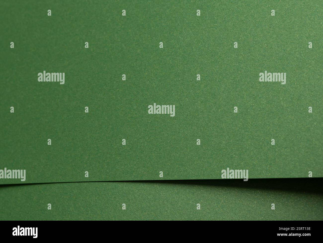 Tiefgrünes Papier mit einer glatten matten Textur und subtilen geometrischen Mustern. Stockfoto
