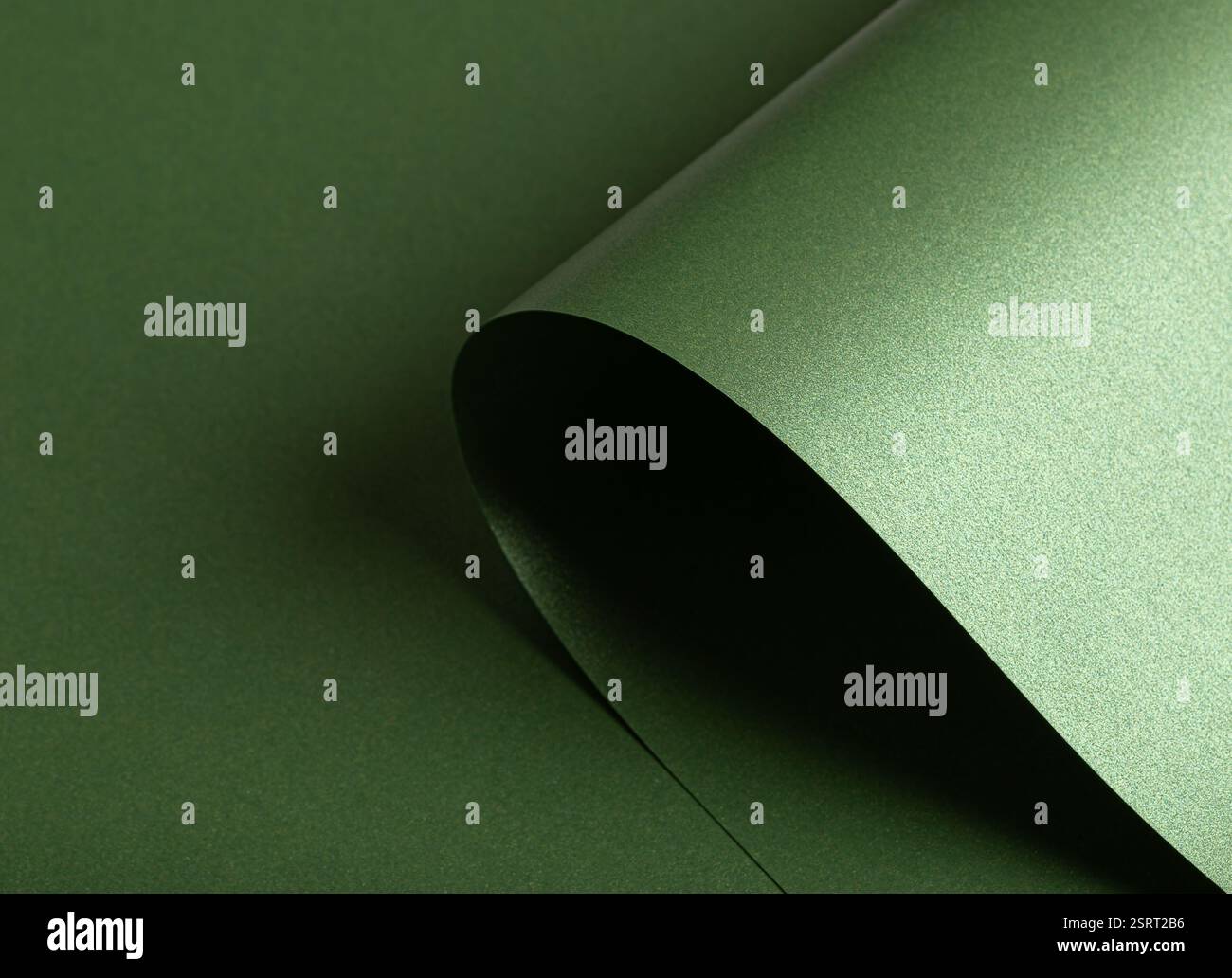 Smaragdgrüner Papierhintergrund mit einer perlmuttartigen, glänzenden Textur. Tiefe Wald- und Salbeitöne schaffen eine elegante, luxuriöse und raffinierte Abstraktion Stockfoto