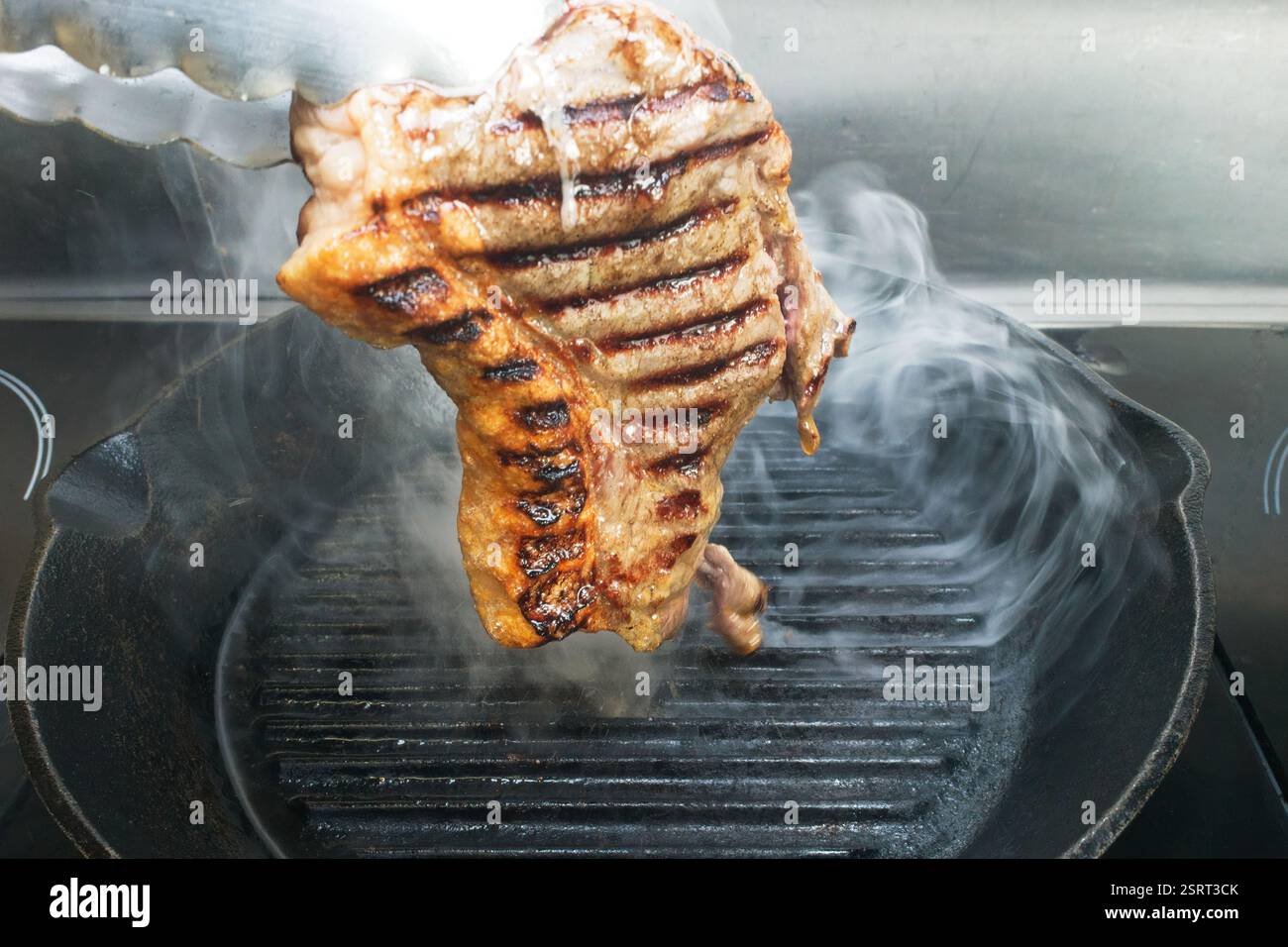 Eine Sammlung von Bildern, die die Technik des Bratens von Lendensteak in einer gusseisernen Pfanne demonstrieren. Das Steak umdrehen. Stockfoto