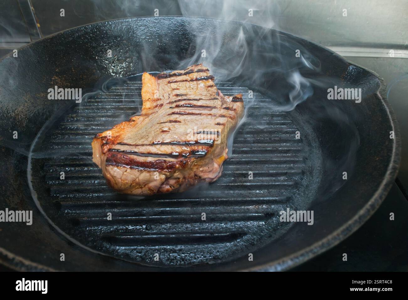 Eine Bilderserie, die die Methode des Bratens von Lendensteak in einer gusseisernen Pfanne veranschaulicht. Stockfoto