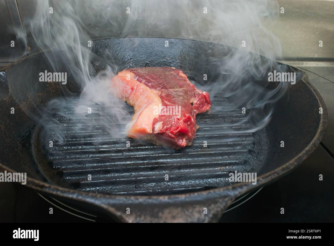 Eine Bilderserie, die die Schritte zum Braten von Lendensteak in einer gusseisernen Pfanne veranschaulicht. Stockfoto