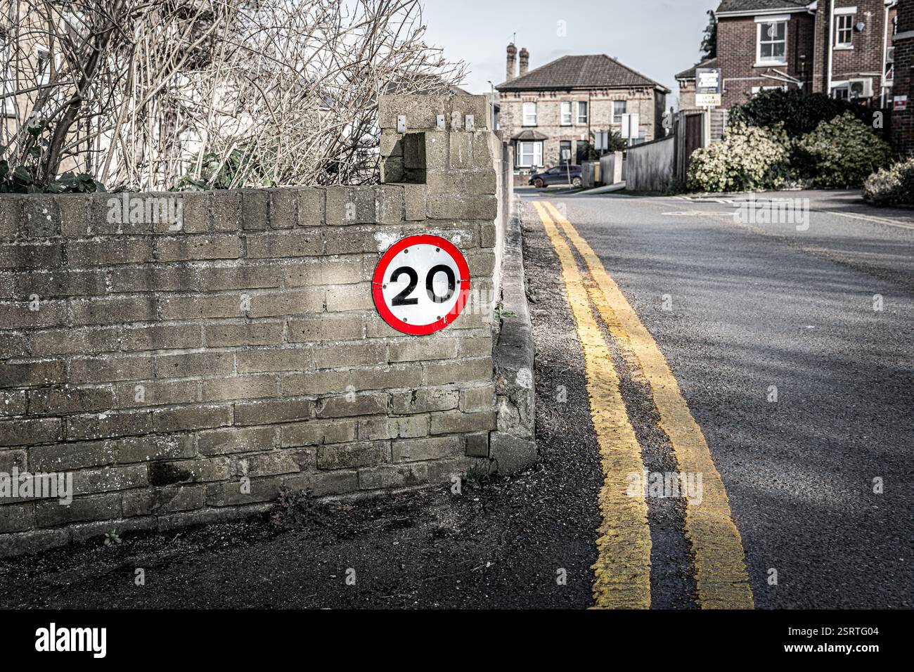 Straßenschild zur Begrenzung der Geschwindigkeit auf 32 km/h in Großbritannien neben doppelten gelben Linien, um das Parken auf der Straße zu verhindern Stockfoto