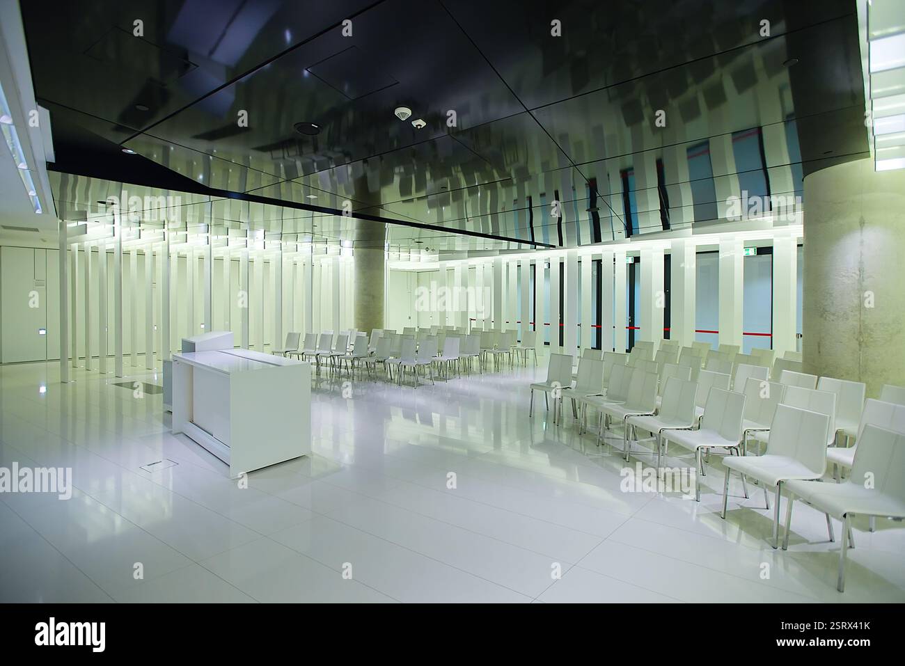 Eine minimalistische, weiße Kapelle im PGE Narodowy, Warschau, empfängt Menschen aller Religionen. Ein neutraler Raum mit einfachen weißen Stühlen und Wänden. Stockfoto