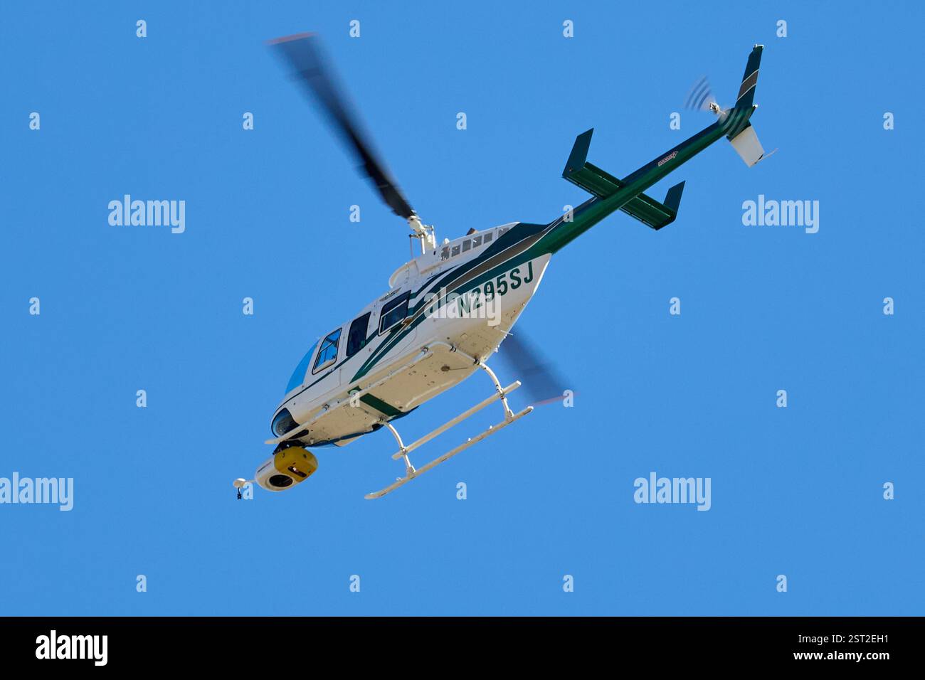 Palm Springs, Kalifornien, USA. Februar 2025. Ein Bell 206-L4 Hubschrauber mit der Nummer N295SJ wird während des Fluges über Palm Springs gefangen genommen. Unter seiner Nase befindet sich das Heliscope 2,0 von Sharper Shape, ein fortschrittliches Nutzlastsystem mit mehreren Sensoren, das für umfassende Inspektionen aus der Luft entwickelt wurde. Dieses System integriert mehrere Sensoren in einer einzigen, leichten Einheit, wodurch die gleichzeitige Erfassung verschiedener Datentypen ermöglicht wird, die für die Wartung von Versorgungseinrichtungen und das Management von Vegetation unerlässlich sind. Die Anwesenheit des Heliscope 2,0 deutet darauf hin, dass der Hubschrauber an detaillierten Luftaufnahmen beteiligt ist, wobei der Schwerpunkt wahrscheinlich auf der Infrastruktur liegt Stockfoto