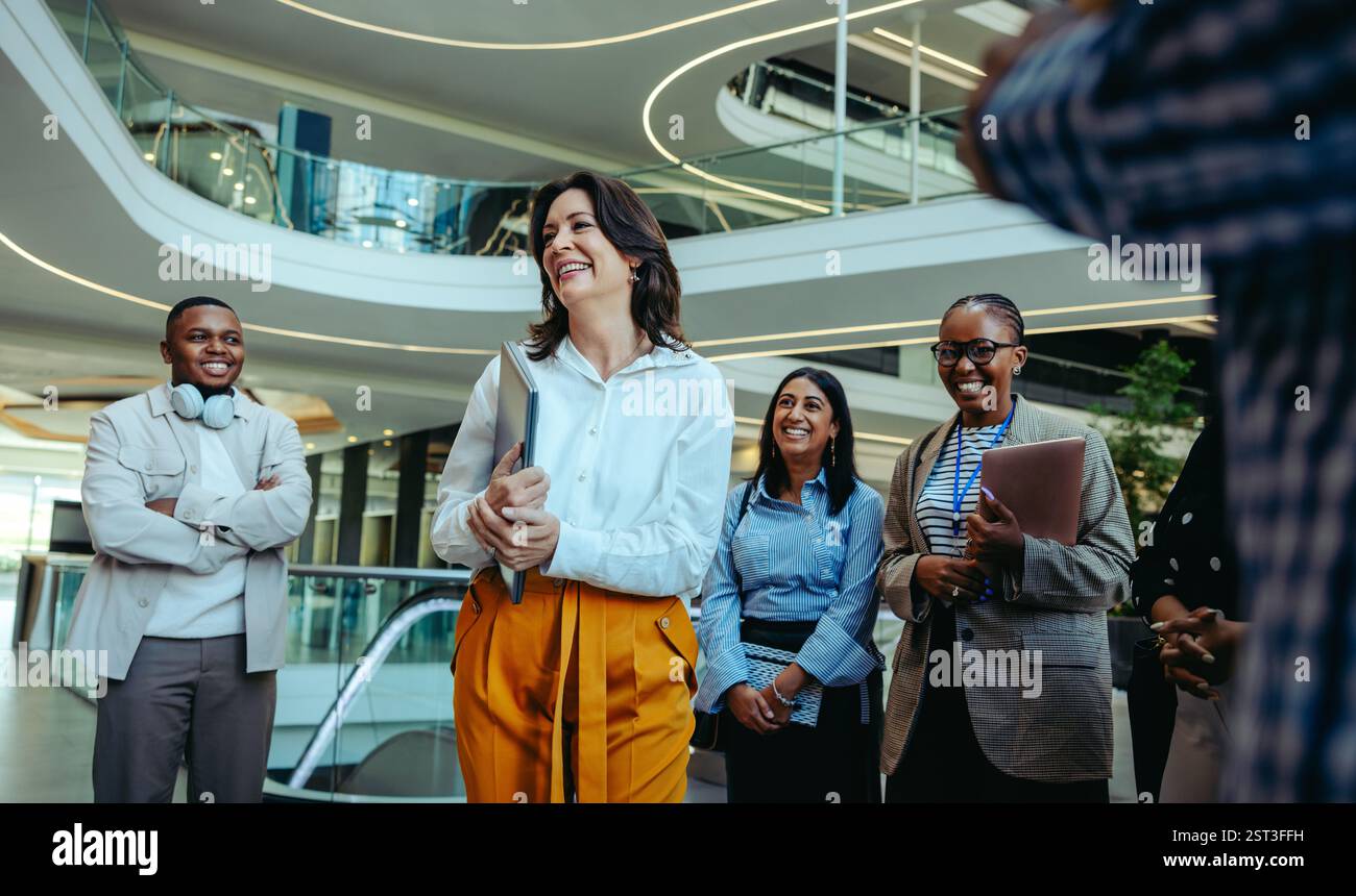 Eine Gruppe professioneller Kollegen, darunter auch ein CFO, wird bei einem geschäftlichen Meeting am ersten Tag mit einem Lächeln und Selbstvertrauen konfrontiert. Stockfoto