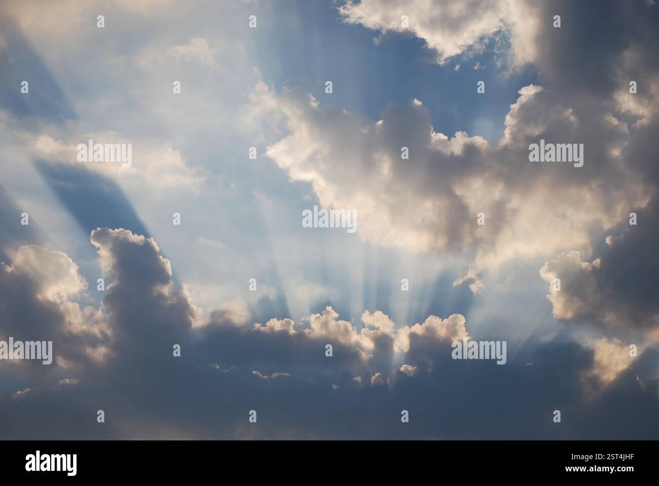 Sonnenstrahlen brechen tagsüber durch dramatische Wolken am Himmel Stockfoto
