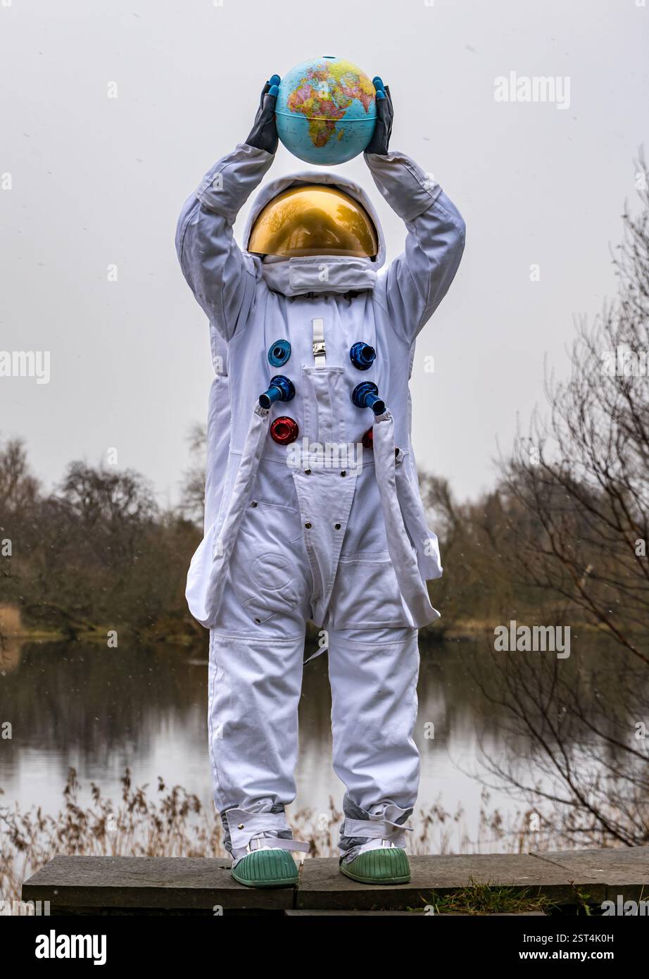 Dr. Neils Garden, Edinburgh, Schottland, Vereinigtes Königreich, 17. Februar 2025. Edinburgh Science Festival: Das Programm für das Festival wird heute gestartet. Das Festival 2025 fordert alle dazu auf, „wie ein Astronaut zu leben“ und die Herausforderungen des Lebens auf einem Planeten mit endlichen Ressourcen durch die Linsen von Science-Fiction und Weltraumforschung zu erkunden. Ein Astronaut, der einen Globus hält, veranschaulicht das Thema, während der Schnee fällt. Quelle: Sally Anderson/Alamy Live News Stockfoto