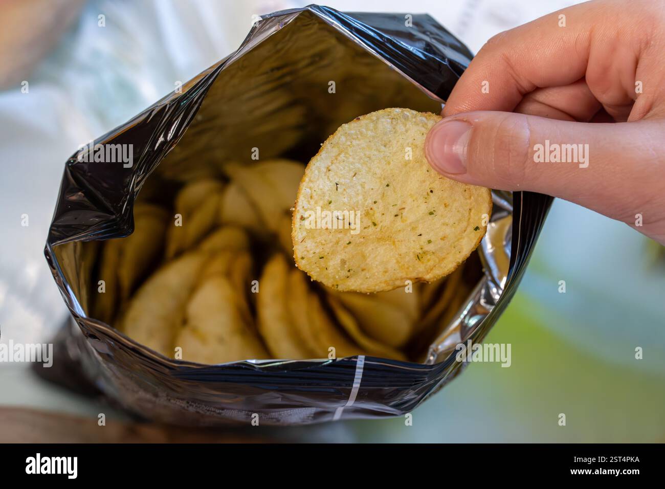 Knusprige Kartoffelchips in Aluminium-Metallbeutelverpackung. Das Konzept einer ungesunden Ernährung und Lebensweise. Beutel Kartoffelchips Stockfoto