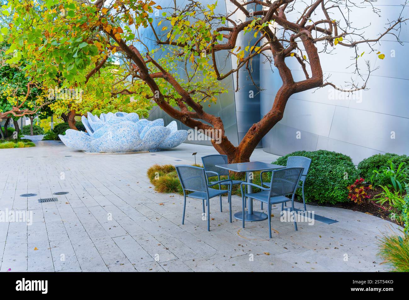 Los Angeles, Kalifornien - 7. Januar 2025: Charmanter Sitzbereich unter einem Baum mit Blick auf einen einzigartigen Mosaikbrunnen im Blue Ribbon Garden im Stockfoto