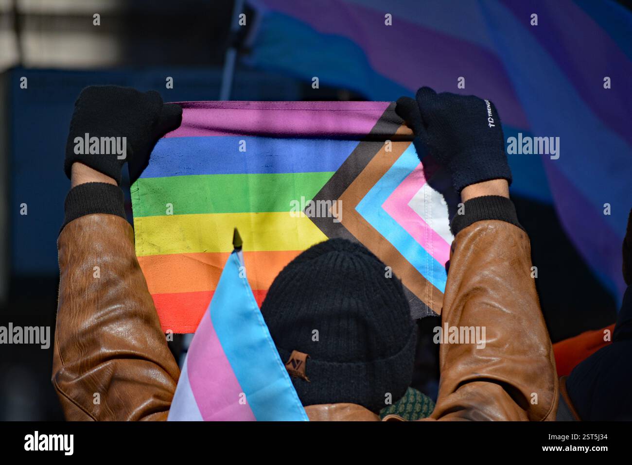 Person mit Progress Pride Flag bei einem Protest vor dem Stonewall Inn in New York City. Stockfoto