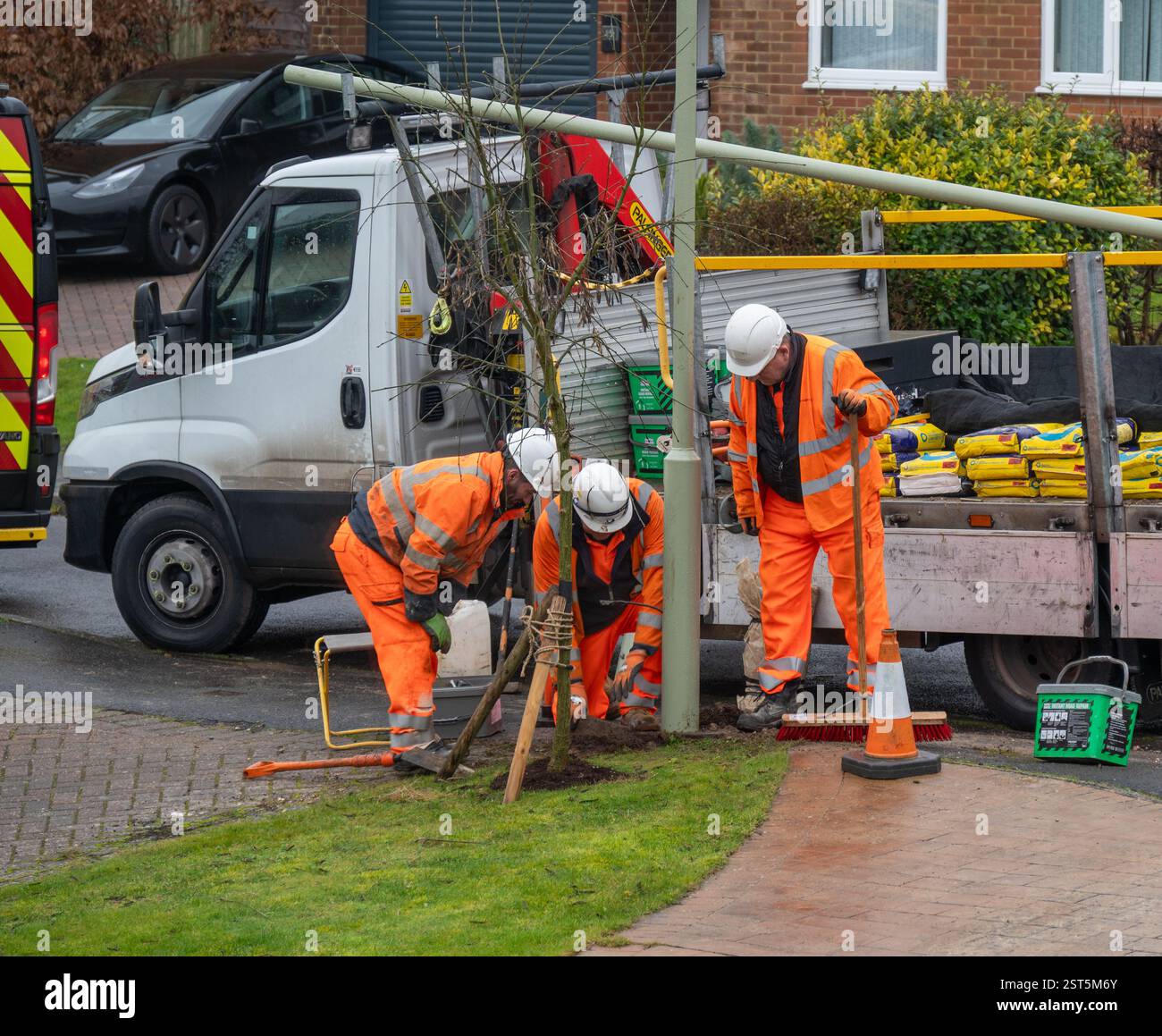 Arbeiter reparieren einen Laternenpfosten auf der Straße nach einem Unfall. Stockfoto