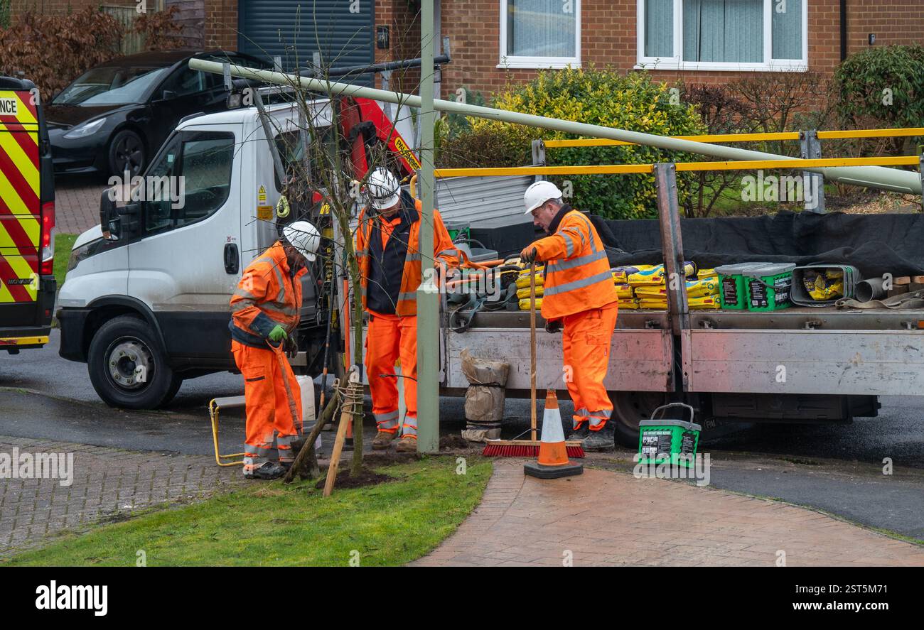 Arbeiter reparieren einen Laternenpfosten auf der Straße nach einem Unfall. Stockfoto