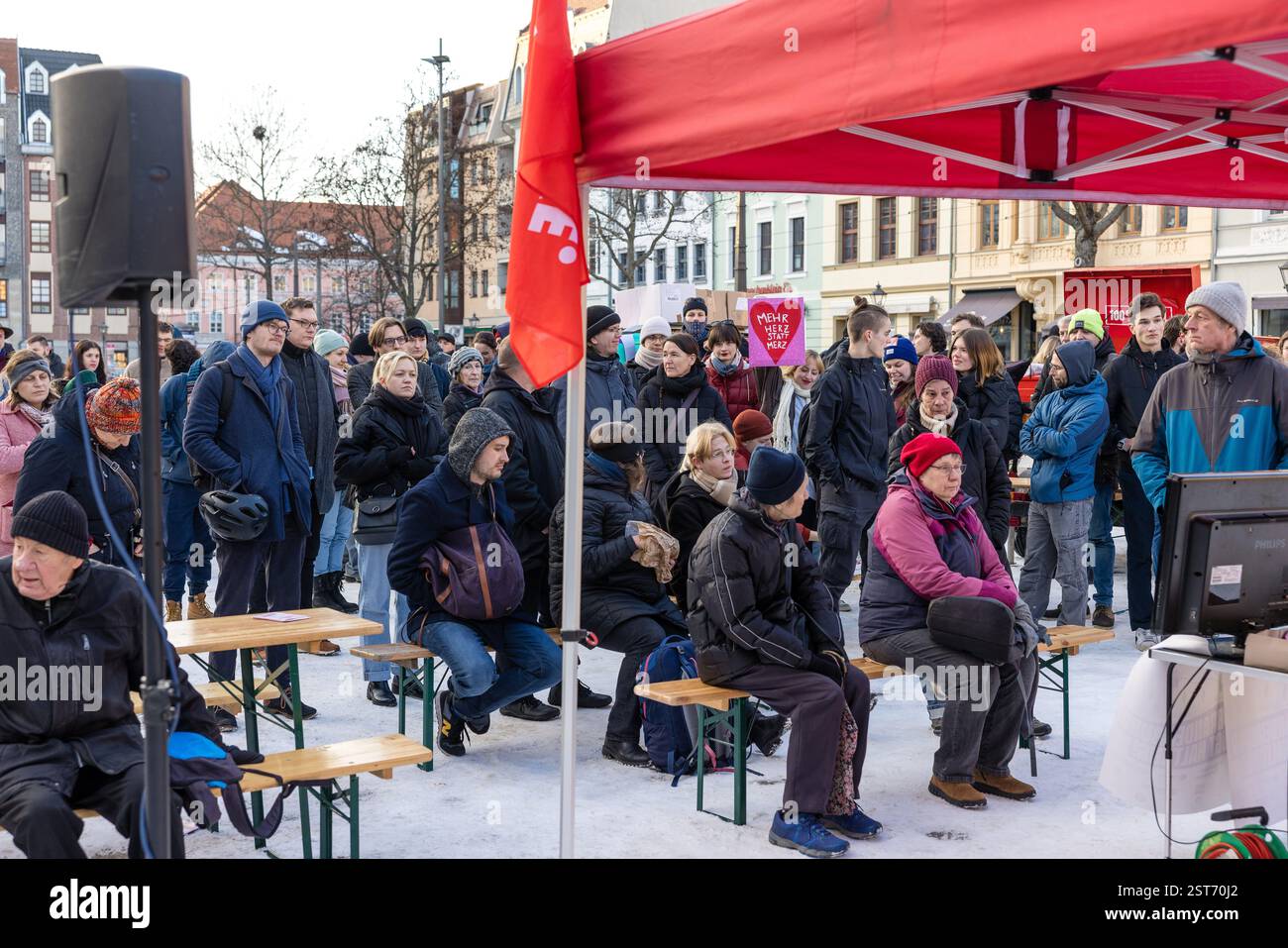 Cottbus, Deutschland. Februar 2025. Menschen, die bei einer Wahlkampfveranstaltung der Linkspartei keinen Platz in der Halle finden konnten, beobachten die Veranstaltung auf dem Altmarkt. Nach dem Ende der Ampelkoalition und der Auflösung des 20. Deutschen Bundestages sind für den 23. Februar 2025 Neuwahlen für den Bundestag geplant. Vermerk: Frank Hammerschmidt/dpa/Alamy Live News Stockfoto