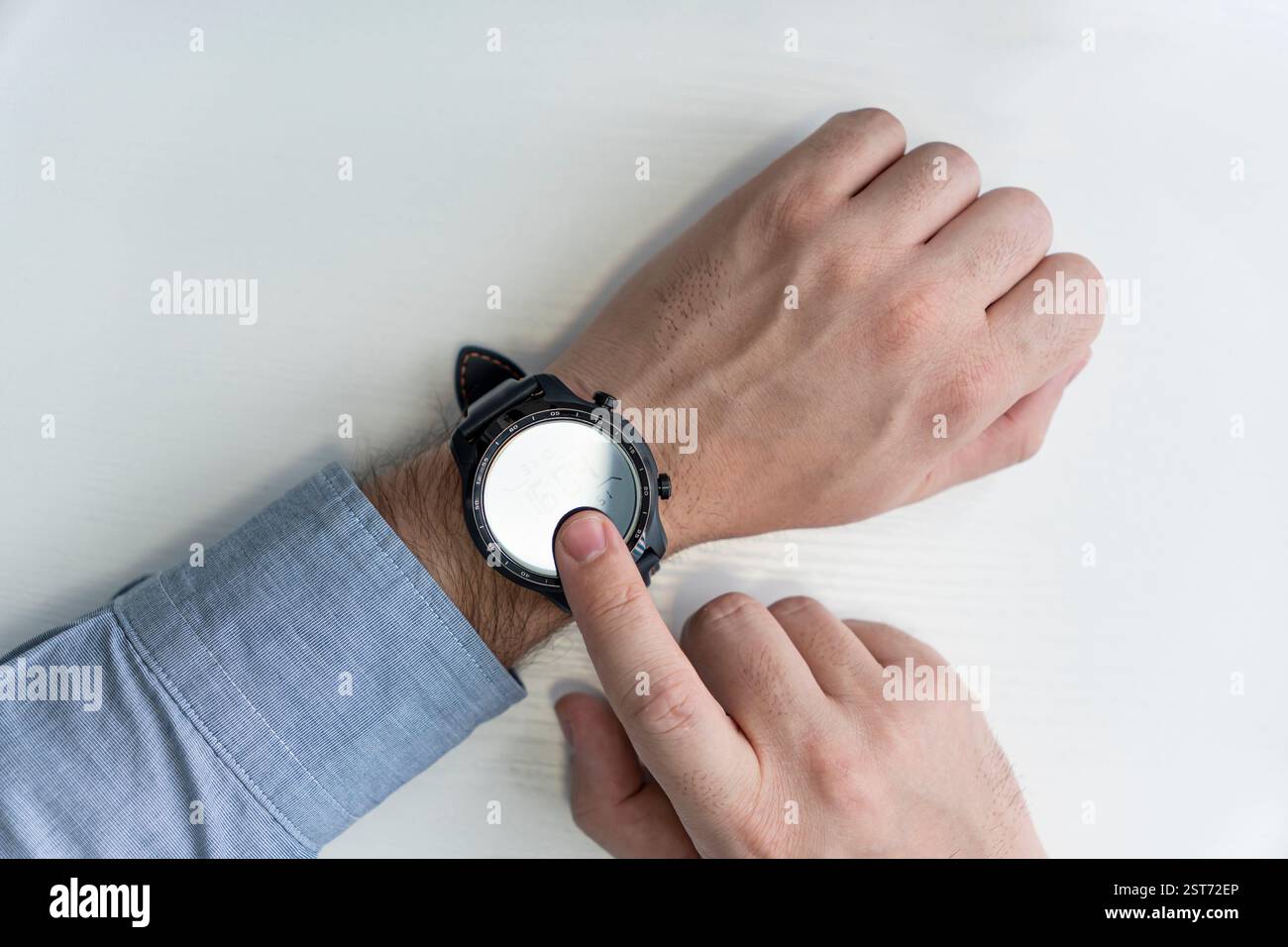 Der Mann drückt seinen Finger auf den Bildschirm seiner Smartwatch. Draufsicht Stockfoto