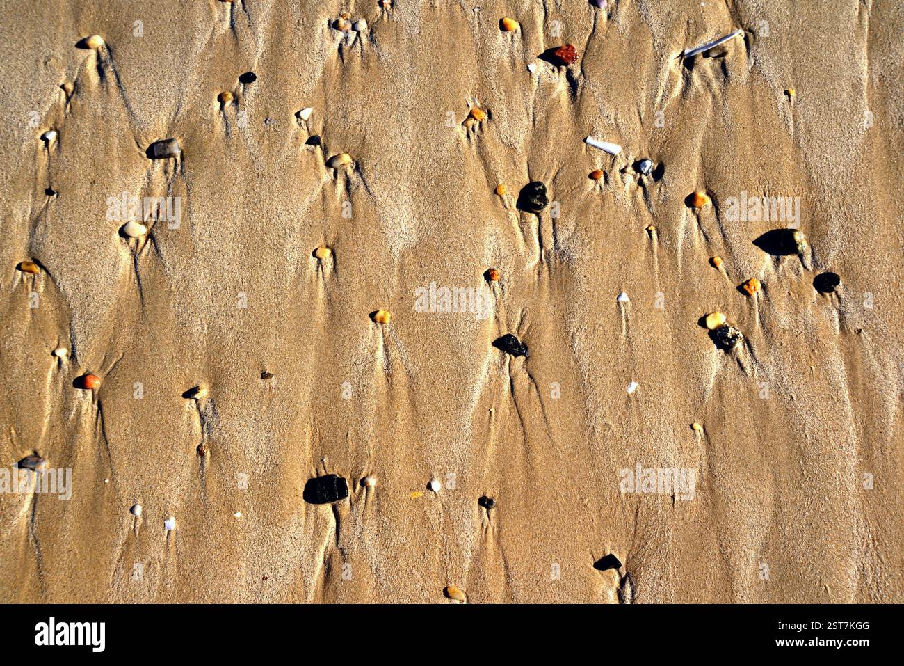 Natürliche Zeichnungen, die die Bewegung des Wasserflusses im Sand veranschaulichen Stockfoto