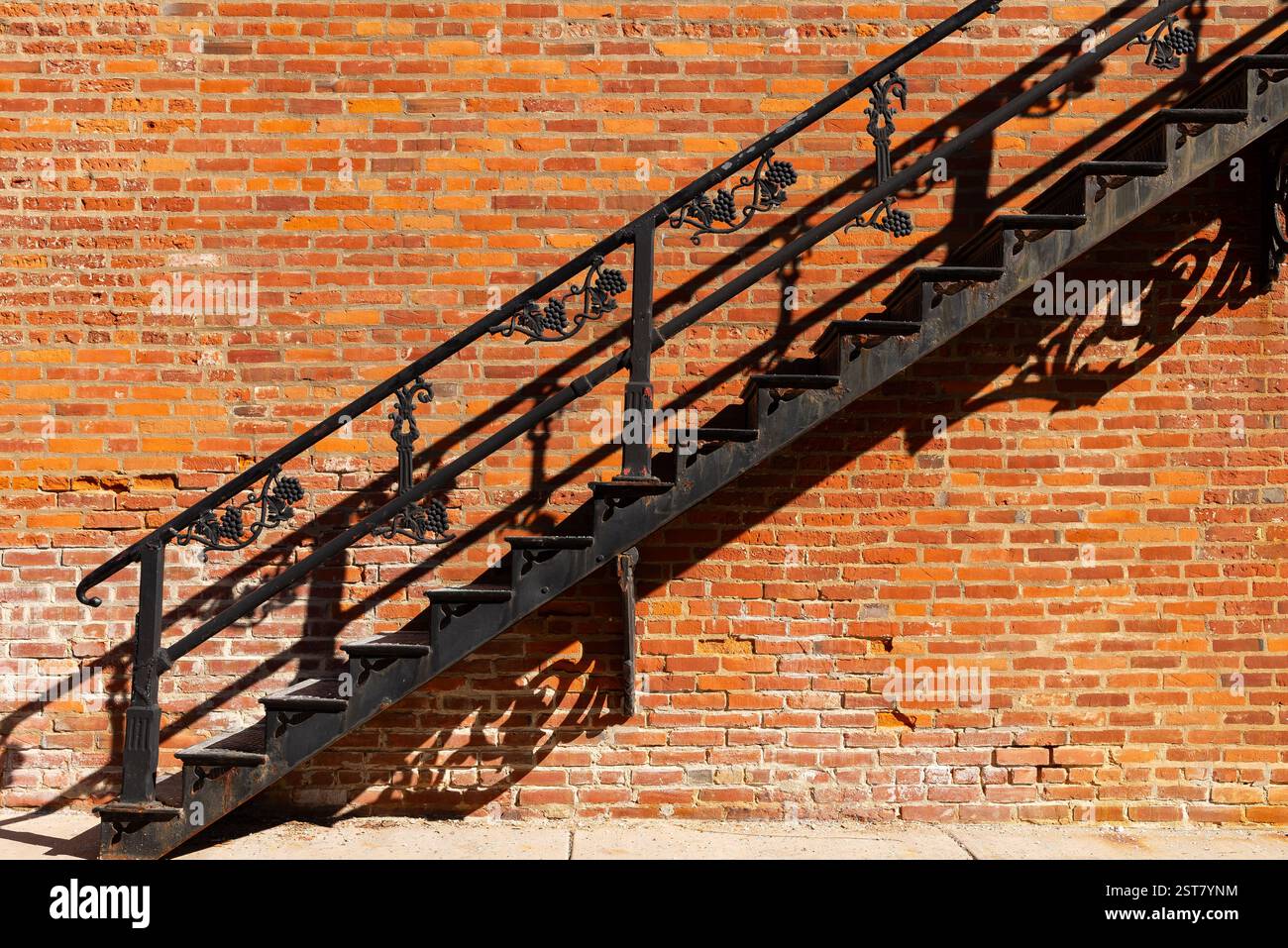 Schwarze Metalltreppe mit rotem Backsteinhintergrund. Stockfoto