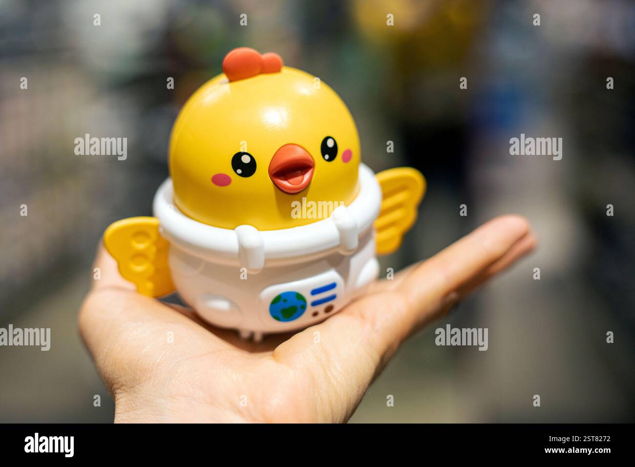 Halten Sie ein Plastikspielzeug-Huhn in der Handfläche. Vorbereitung auf den Feiertag, Ostern Stockfoto