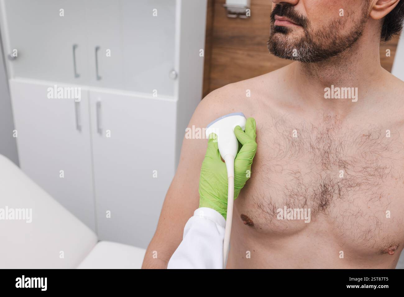 Nahaufnahme des Ultraschallsensors des Ultraschallgerätes im Bereich der menschlichen Schulter zur Überprüfung der Gesundheit der Schulter des Patienten. Schulterultraschall Stockfoto