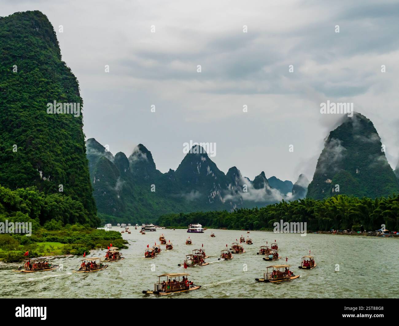 Kreuzfahrtschiffe und Bambusboote fahren durch malerische Landschaften entlang des Flusses Li von Guilin nach Yangshou, China Stockfoto
