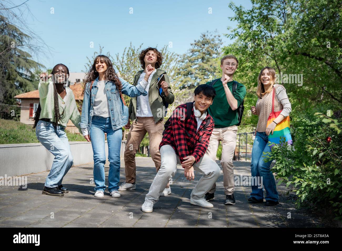 Eine Gruppe verschiedener junger Freunde, die an einem sonnigen Tag im Freien lachen und Spaß haben. Konzept von Freundschaft, Jugend und Glück. Stockfoto
