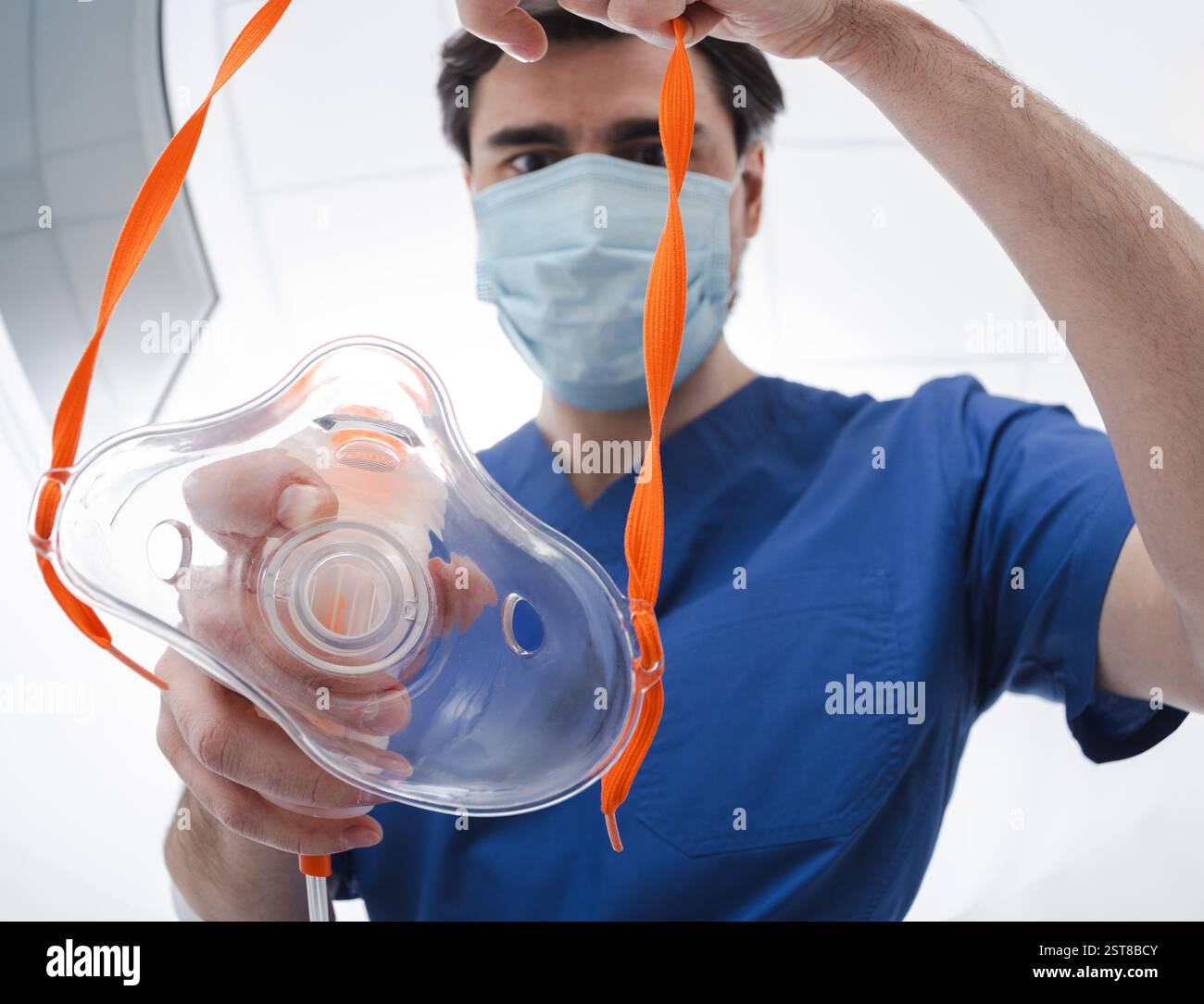 Medizinisches Fachpersonal in Peelings und Schutzmaske bereitet eine Atemmaske mit Sauerstoff vor und gibt sie einem Patienten mit Atemproblemen, Nahaufnahme Stockfoto
