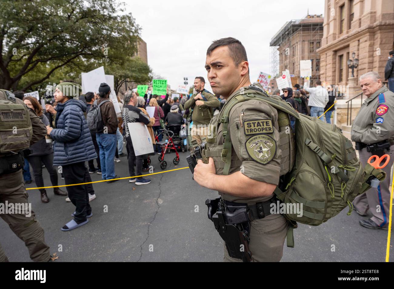 Austin, Texas USA, 17. Februar 2025: Der junge Texas State Trooper steht während einer politischen Kundgebung in der Hauptstadt von Texas. Demonstranten sammelten sich gegen Präsident Donald Trump und den Milliardär Elon Musk, deren Aktionen in den letzten drei Wochen Tausende von Regierungsstellen abgeschnitten, viele Regierungsfunktionen beseitigt und viele zuvor stabile Systeme ins Chaos gebracht haben. ©Bob Daemmrich Stockfoto
