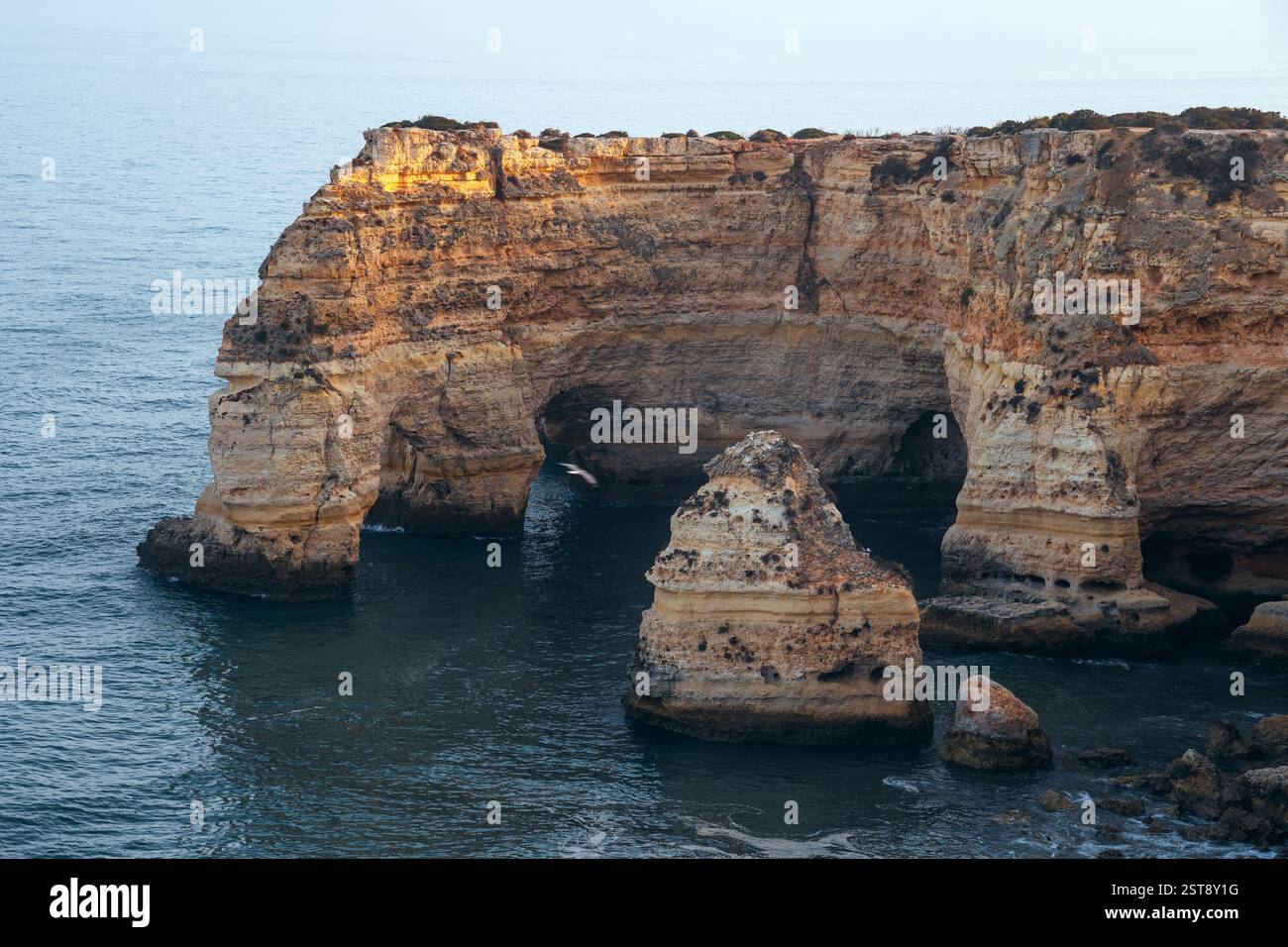 Klippen, Felsformationen und Naturbögen am Strand La Marina bei Sonnenuntergang in der Algarve in der Nähe der Städte Albufeira und Portimao. Portugal. Stockfoto