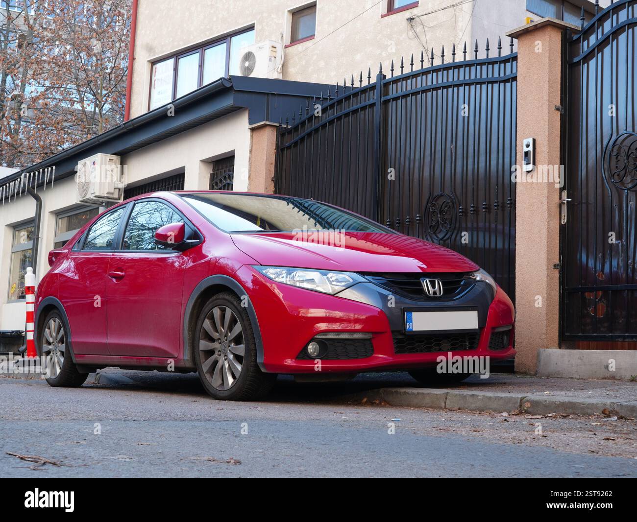 Bukarest, Rumänien – 9. Januar 2025: Roter Honda Civic parkt auf der Straße vor dem Haus. Nahansicht der Vorderseite. Stockfoto