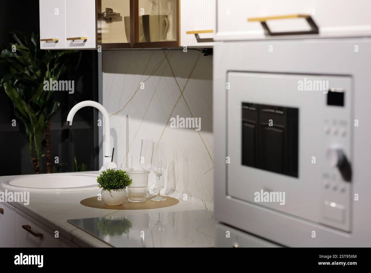 Nahaufnahme einer kleinen Küchenarbeitsfläche mit rundem Waschbecken und Induktionsherd. Selektiver Fokus. Stockfoto