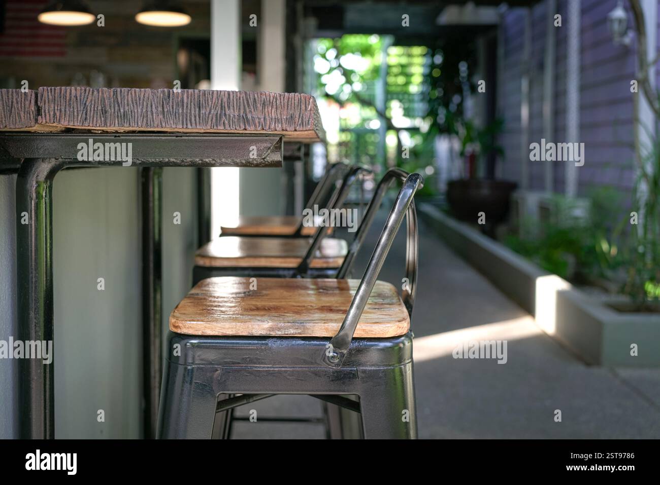 Bartheke aus Holz mit hohen Hockern. Nahansicht. Stockfoto