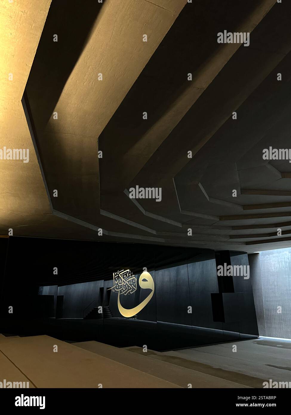 Dieses fesselnde Bild zeigt ein architektonisches Meisterwerk mit scharfen geometrischen Linien und dramatischer Beleuchtung. Das Zusammenspiel von Licht und Schatten auf t Stockfoto