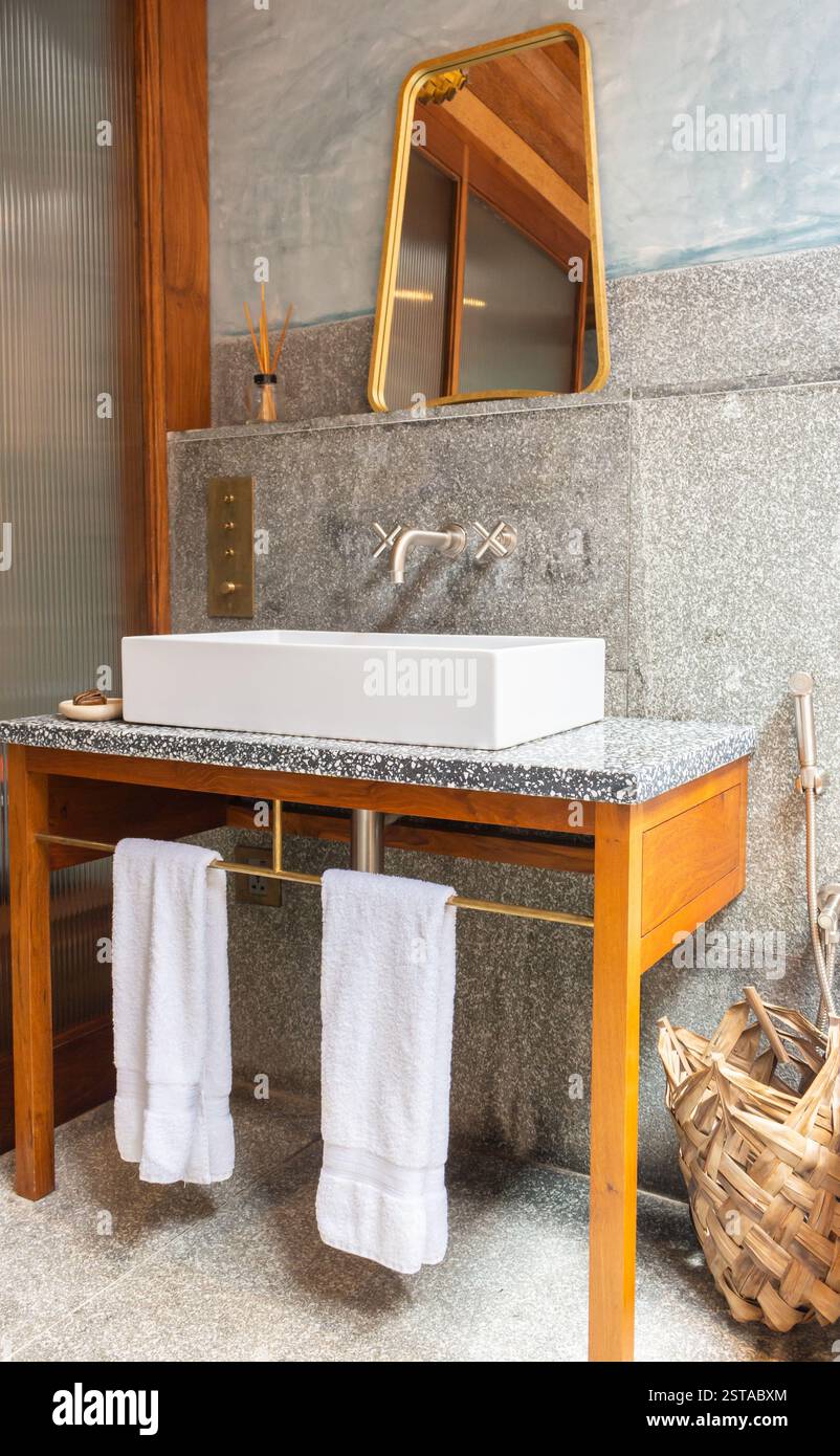 Hotelbadezimmer innen. Bad mit Handtüchern und Spiegel. Holzmöbel im Badezimmer. Luxuriöses Hoteldesign. Wellness- und Hygienekonzept. Stockfoto