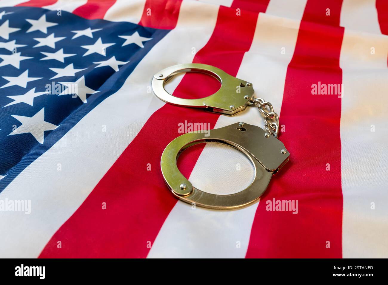 amerikanische Flagge und Handschellen der Polizei. Der Begriff der Einhaltung des Gesetzes im Land und des Schutzes vor Verbrechen Stockfoto